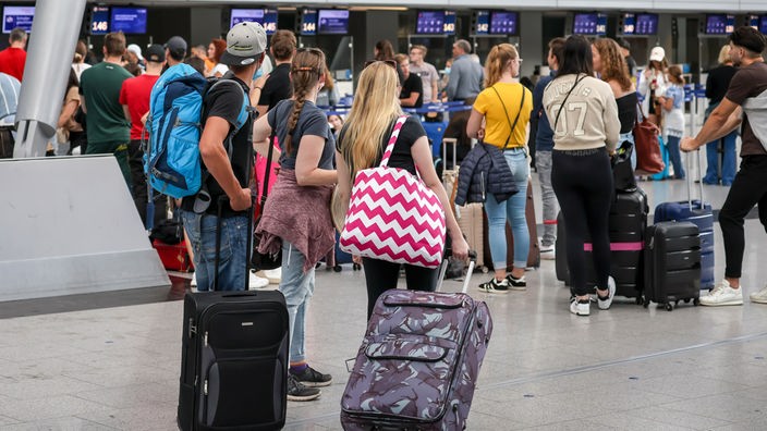 Reisende warten vor einem Schalter am Düsseldorfer Flughafen