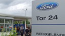 Mitarbeiter stehen vor Tor 24 des Ford-Werkgeländes