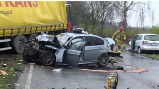 Die Motorhaube eines grauen Autos ist eingedrückt