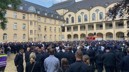 Die trauernde Menge: Feuerwehrleute gedenken gemeinsam den zwei verstorbenen Einsatzkräften in Sankt Augustin. 