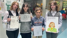Vier Schülerinnen der Käthe-Kollwitz-Gesamtschule präsentieren ihre Arbeiten