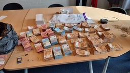 Zu sehen sind einige Stapel beschlagnahmtes Bargeld auf einem Tisch