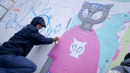 Junge Künstlerin beim Graffiti sprayen