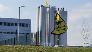 Banner in gelb und schwarz hängt vor Milchsilos