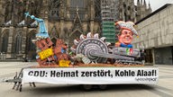 Der Mottowagen von Greenpeace vor dem Kölner Dom.