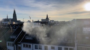 Rauch steigt über Häusern auf.