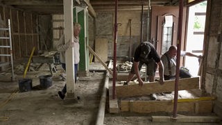 Bauarbeiter beim Wiederaufbau von einem Haus. 