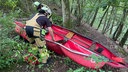 Feuerwehrleute bergen die beschädigten Kanus an einem Steilhang