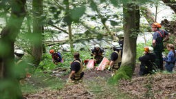 Feuerwehrleute bergen die beschädigten Kanus an einem Steilhang