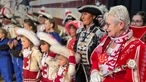 Die Kölnerin Helga I. steht in Richterich auf einer Bühne mit anderen verkleideten Karnevalisten