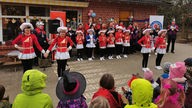 Die KG Kornelimünster tanzt an einer Kita vor verkleideten Kindern