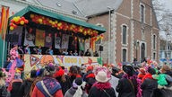 Vor einer Bühne in Eupen feiern viele Menschen Karneval