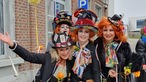 Vier mit Perrücken und Hüten verkleidete Frauen beim Karneval in Eupen