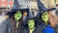 Drei Frauen, die als Hexen verkleidet sind, feiern Karneval in Düren