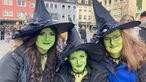 Drei Frauen, die als Hexen verkleidet sind, feiern Karneval in Düren