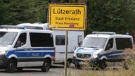 Ortseingangsschild Lützerath und Polizeieinsatzwagen