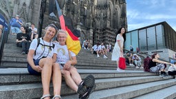 Paar mit Deutschlandflagge vor dem Kölner Dom