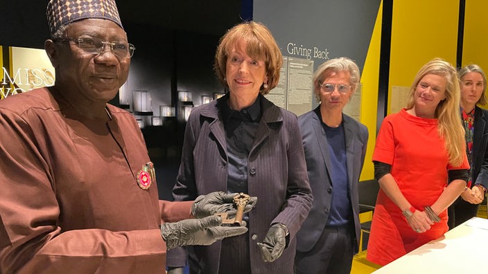 Kölns Oberbürgermeisterin Henriette Reker gibt dem Generaldirektor der National Commission for Museums and Monuments Nigerias, Abba Isa Tijani, eine der Bronzen zurück