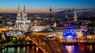 Die helle Kölner Skyline leuchtet in der Nacht