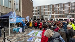 Viele Menschen mit Plakaten stehen vor dem Rathaus in Köln, ein Pavillion weist mit einem Sprecher davor steht ebenfalls dort