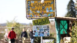 Das von Aktivisten beklebten Dorfeingangs-Schild von Lützerath.