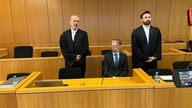 Angeklagter mit Anwälten vor dem Gericht