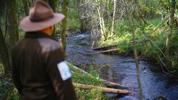 Ein Naturschützer steht vor dem Perlenbach bei Monschau