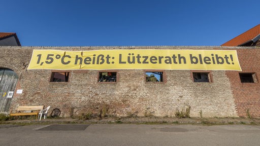 Ein banner mit der Aufschrift "1,5 Grad hießt: Lützerath bleibt!"