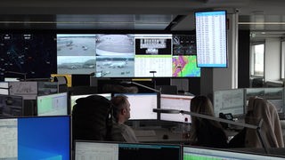 Das Bild zeigt das neue Kontrollzentrum am Flughafen Köln/Bonn. Zu sehen sind viele Monitore, die unterschiedliche Zahlen, Daten und Perspektiven des Flughafens anzeigen.