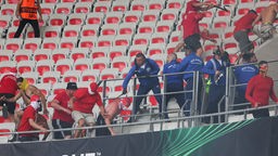 Die gwalttätigen FC-Fans im Stadion in Nizza tragen Köln-Farben und sind zum Teil vermummt. Der Angeklagte in diesem Prozess trägt einen schwarzen Hut.