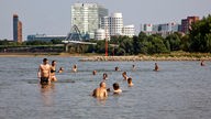 Behörden und DLRG warnen vor dem Schwimmen im Rhein - wie hier in Düsseldorf am Paradiesstrand