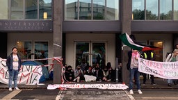 Studierende blockieren den Haupteingang der Uni Köln.