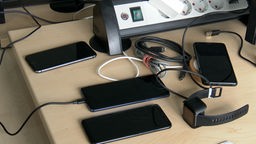 Mehrere Smartphones liegen auf einem Schreibtisch