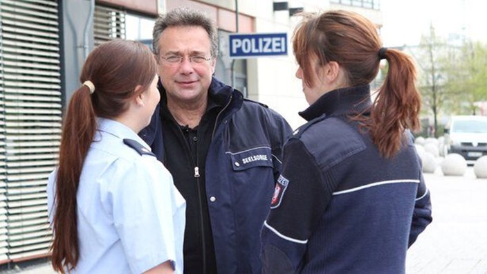 Polizeiseelsorger Rainer Dürscheidt unterhält sich mit zwei Kolleginnen