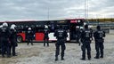 Polizisten einer Hundertschaft vor einem Bus