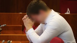 Ein Mann sitzt weinend auf der Anklagebank.
