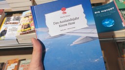 Buch mit blauem Himmel und Flugzeugflügel