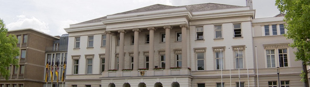 Das Krefelder Rathaus, darüber ein bewölkter Himmel