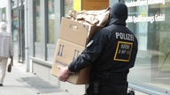 Polizist trägt Pappkarton mit Unterlagen