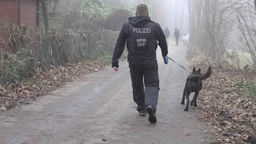 Ein Polizist mit Spürhund bei einer Reichsbürger-Razzia in Wuppertal