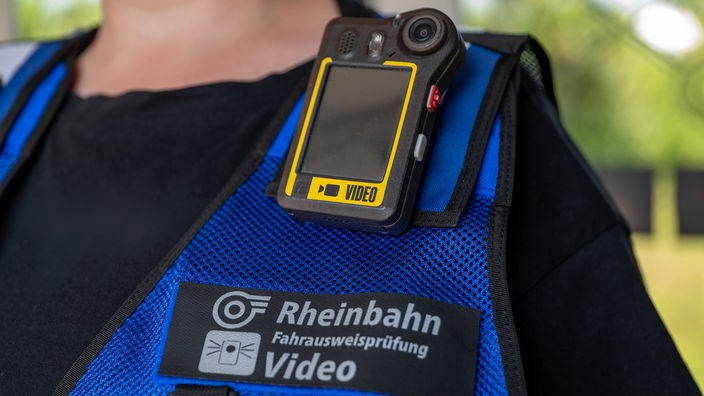 Eine Weste mit Rheinbahn-Logo, darüber eine kleine Videokamera