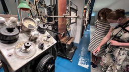 Zwei Frauen stehen im Museum vor technischen Geräten