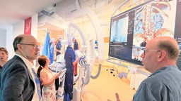 Museumsbesucher stehen vor der Fotografie eines Operationssaales