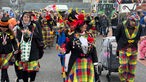 Beim Rosenmontagszug in Übach-Palenberg feiern viele bunt verkleidete Menschen auf der Straße