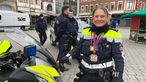 Eine Polizisten in Aachen trägt Karnevalsorden um den Hals