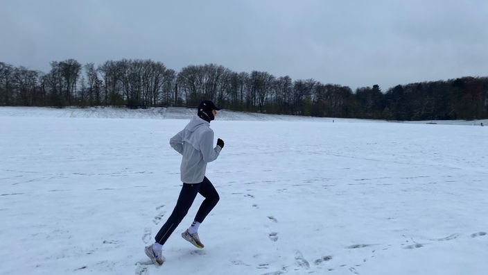 Felix Wittmann joggt über ein verschneites Feld