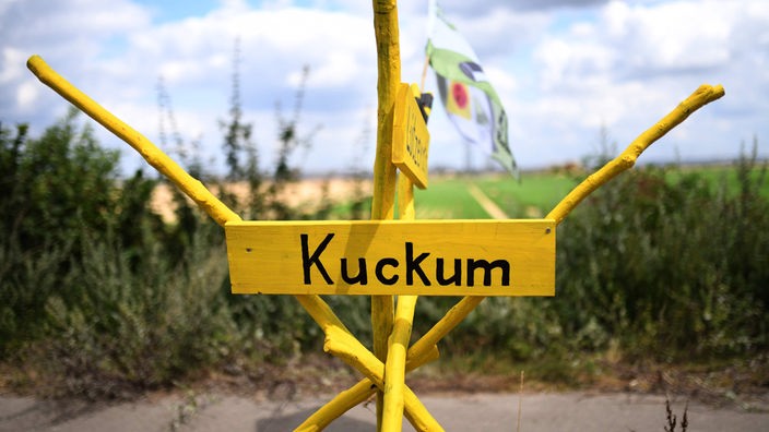 Ein gelbes Schild mit der Aufschrift "Kuckum", welches auf einer Straße in Keyenberg steht