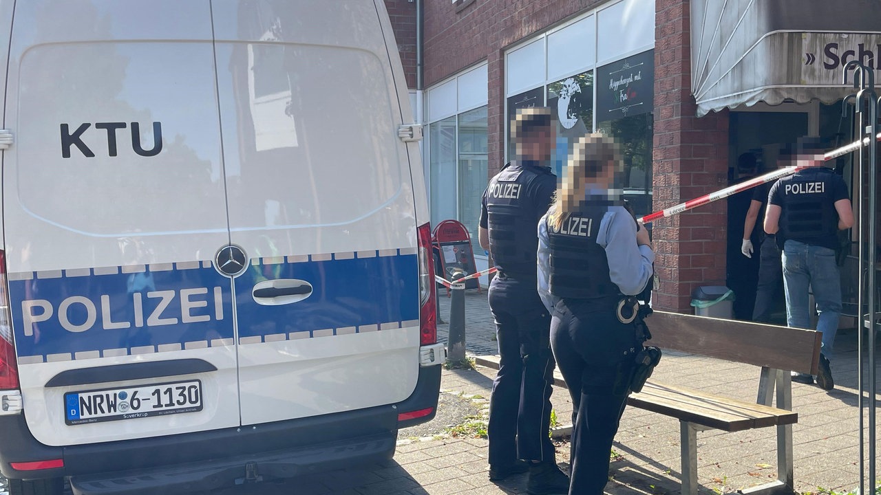 Polizisten stehen vor dem Kiosk