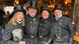 Vier Personen in Schornsteinfeger-Uniform