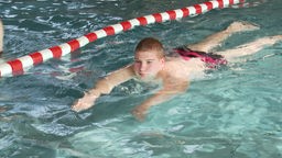 Ein Junge schwimmt in einem Schwimmbad
